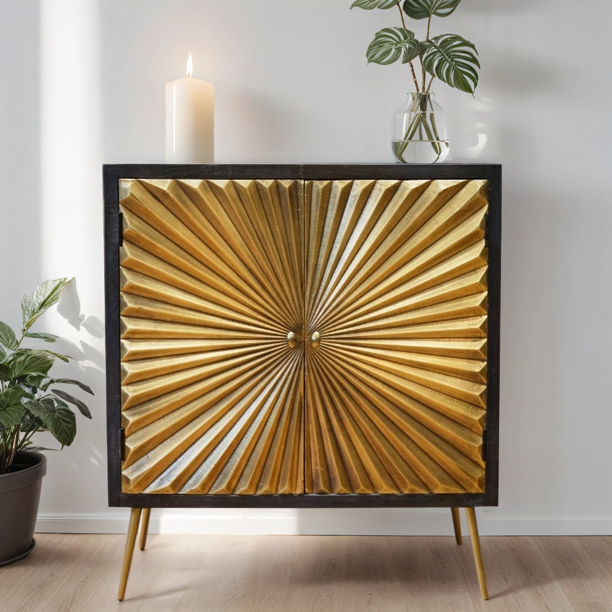 Decorative cabinet with sunburst design in a room with plants and candles.