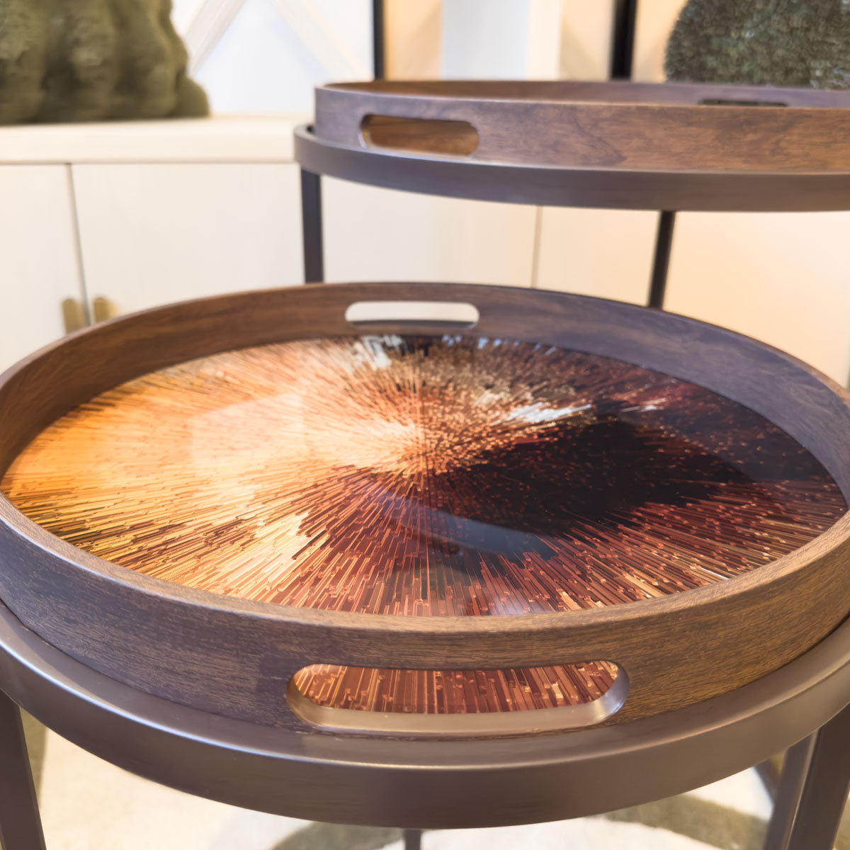 Round wooden tray tables with a rust starburst decorative pattern 