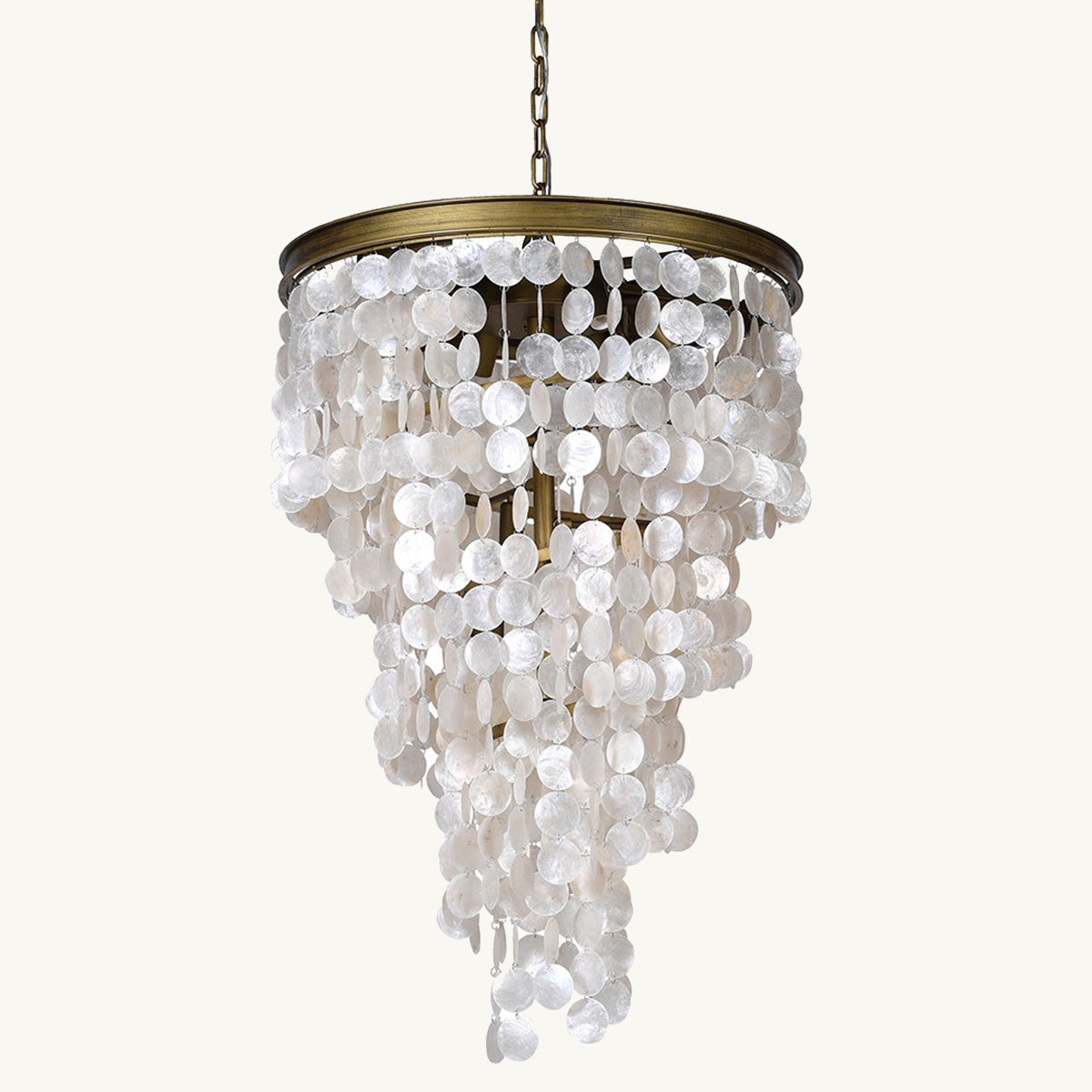 A golden chandelier with tiers of white cascading capiz shells, designed to cast a soft glow.