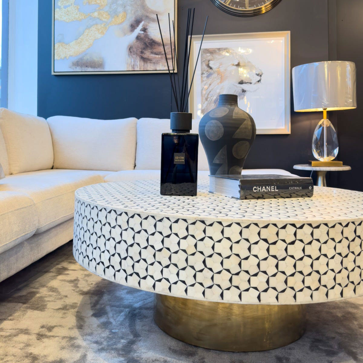 Living room with a round bone coffee table, decorative items, and a couch.