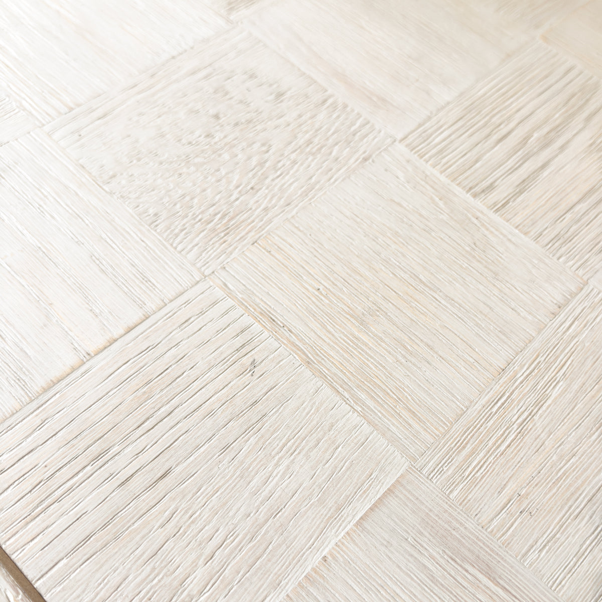 Close-up of a light natural wood parquet console with a textured grain finish.