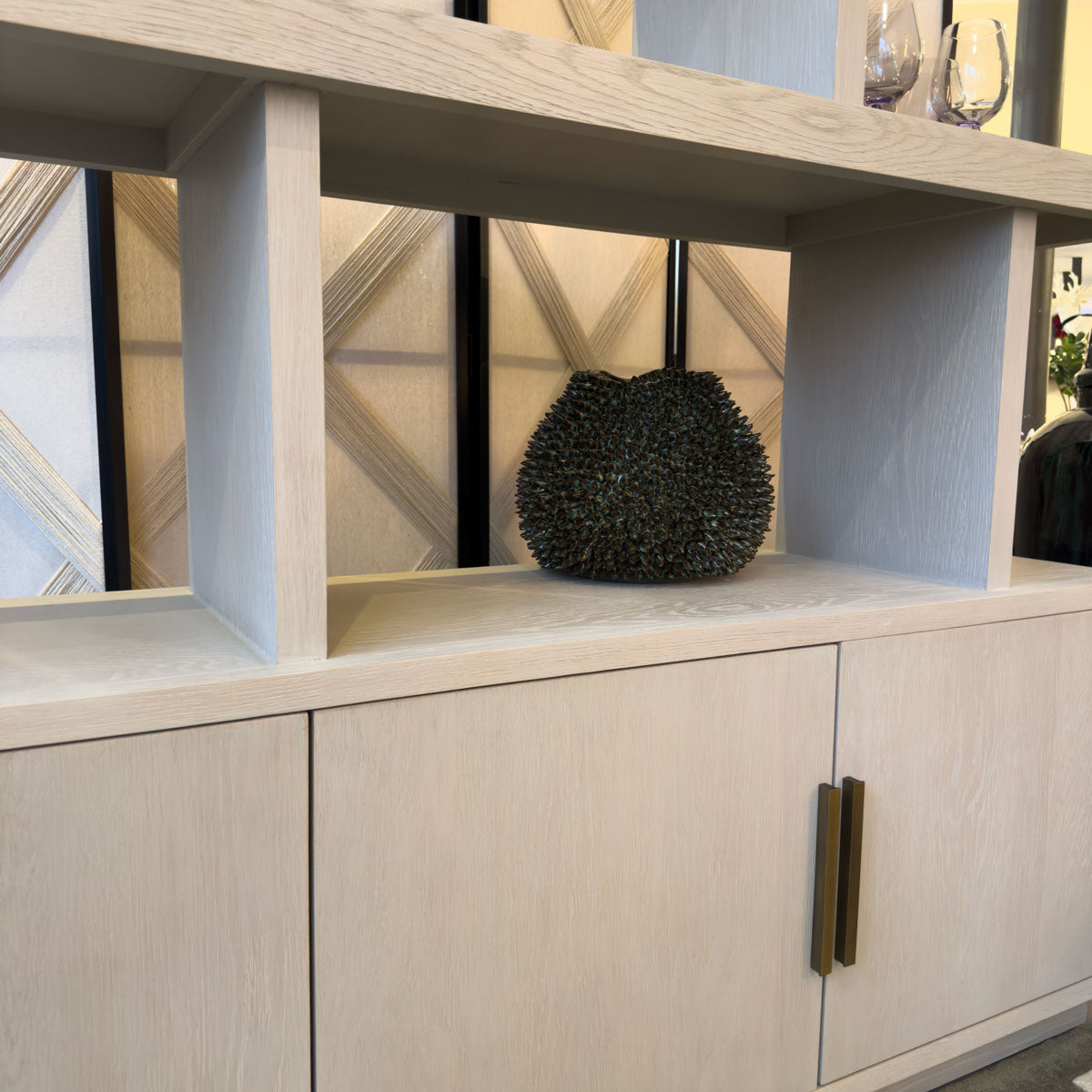 Decorative vase on a cream wooden shelf with doors