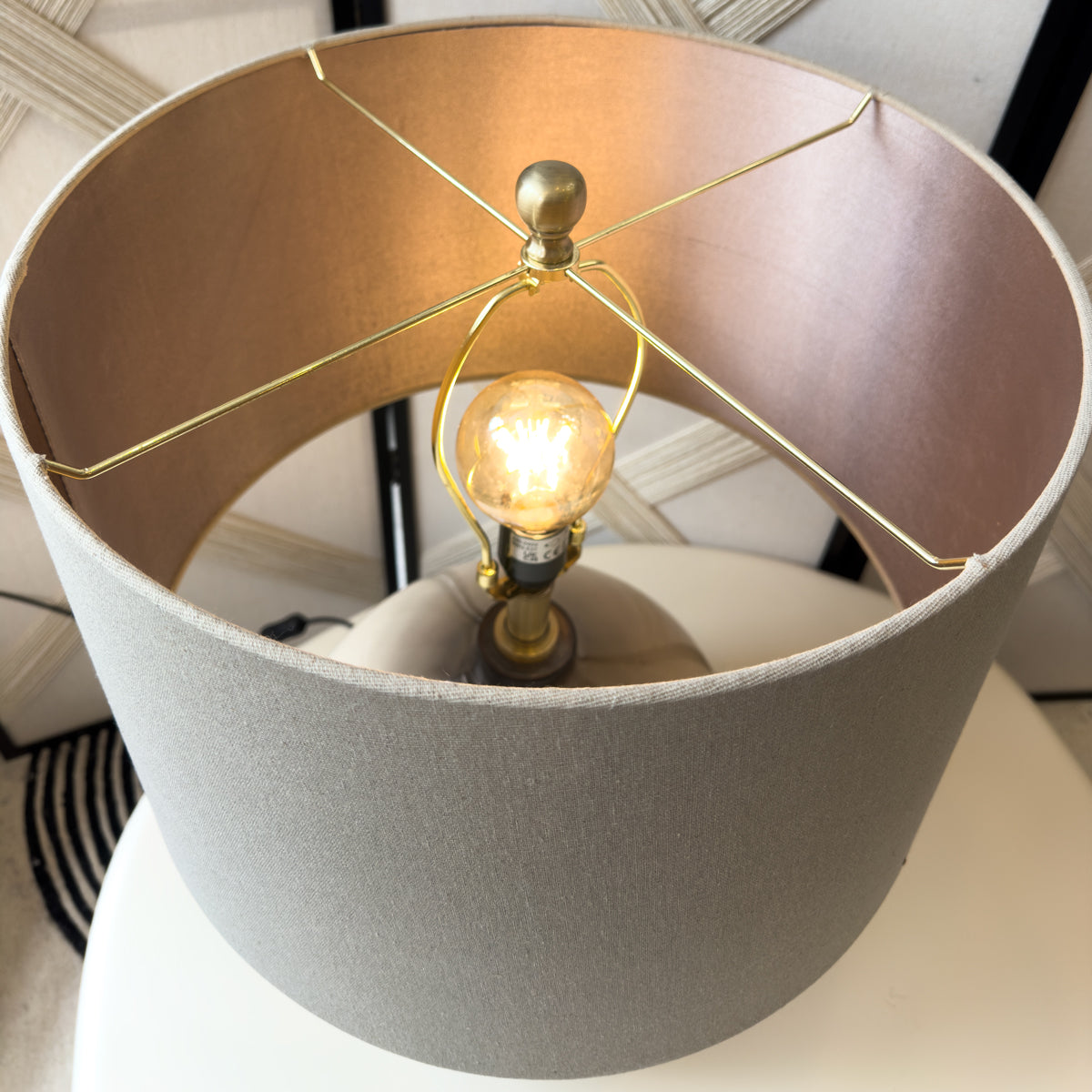 Close-up of a lamp with a gold bulb holder and brown shade.