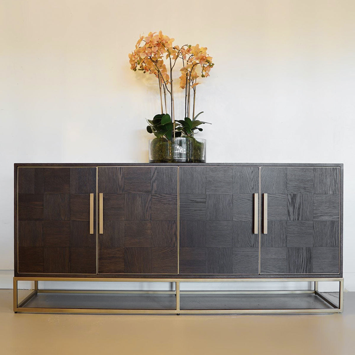 Modern parquet dark wood sideboard with decorative flowers on a neutral background