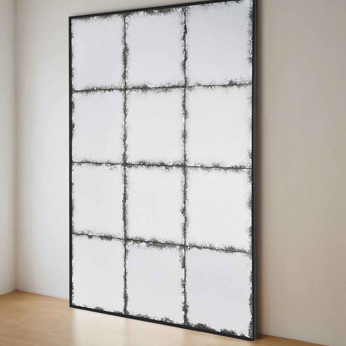 A distressed grid mirror with black frame sitting in a neutral room.