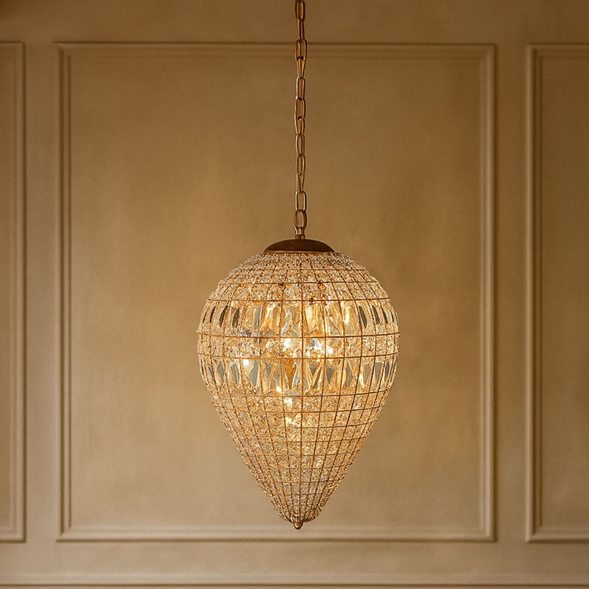 Decorative teardrop pendant light hanging against a beige wall.