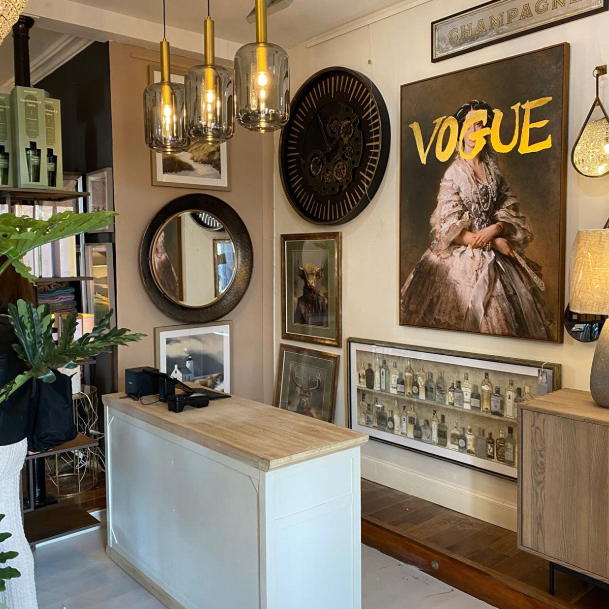 Decorative interior with wall art, mirrors, and a 'Vogue' poster.