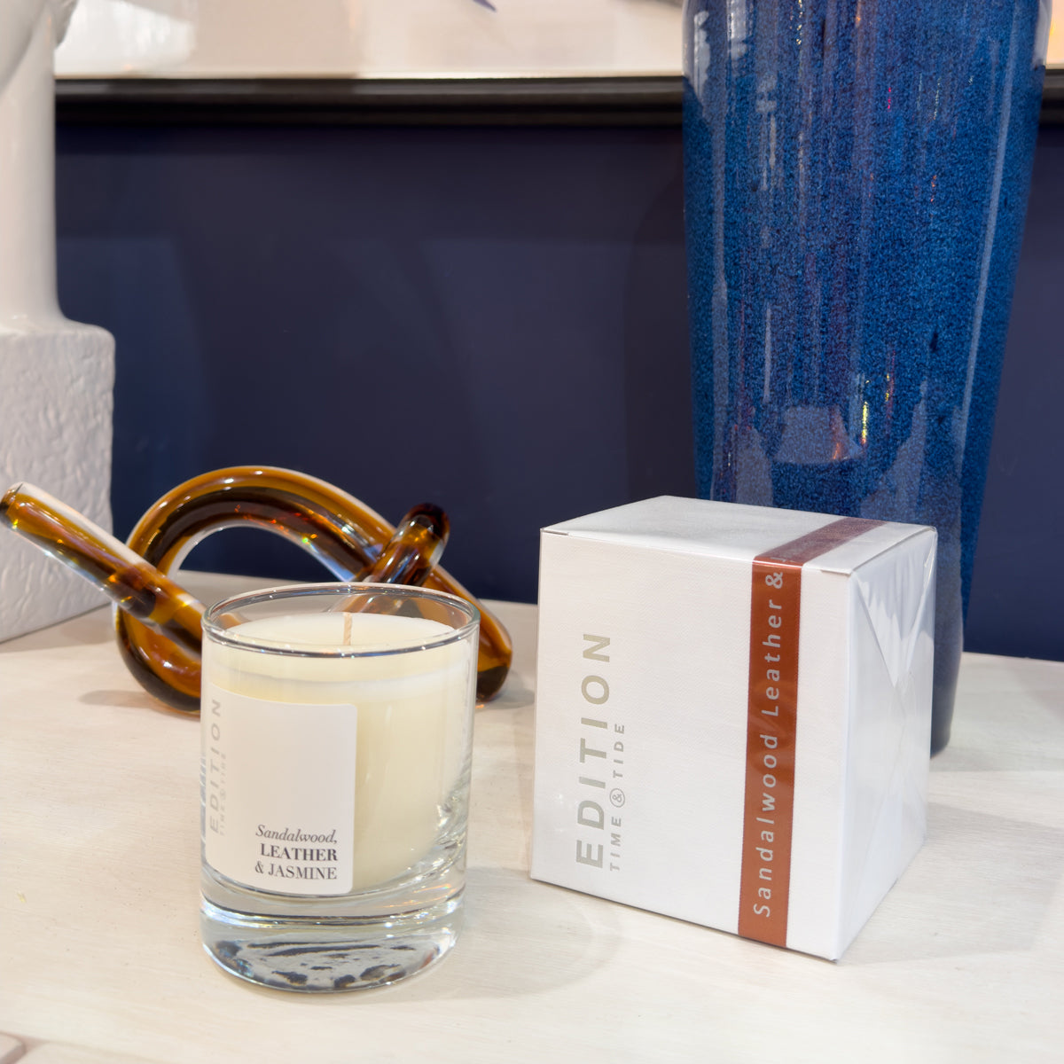 Scented leather candle with packaging on a surface