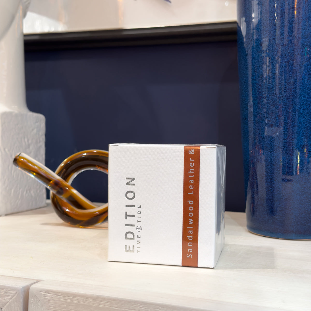 White box with 'EDITION' branding on a shelf with decorative items