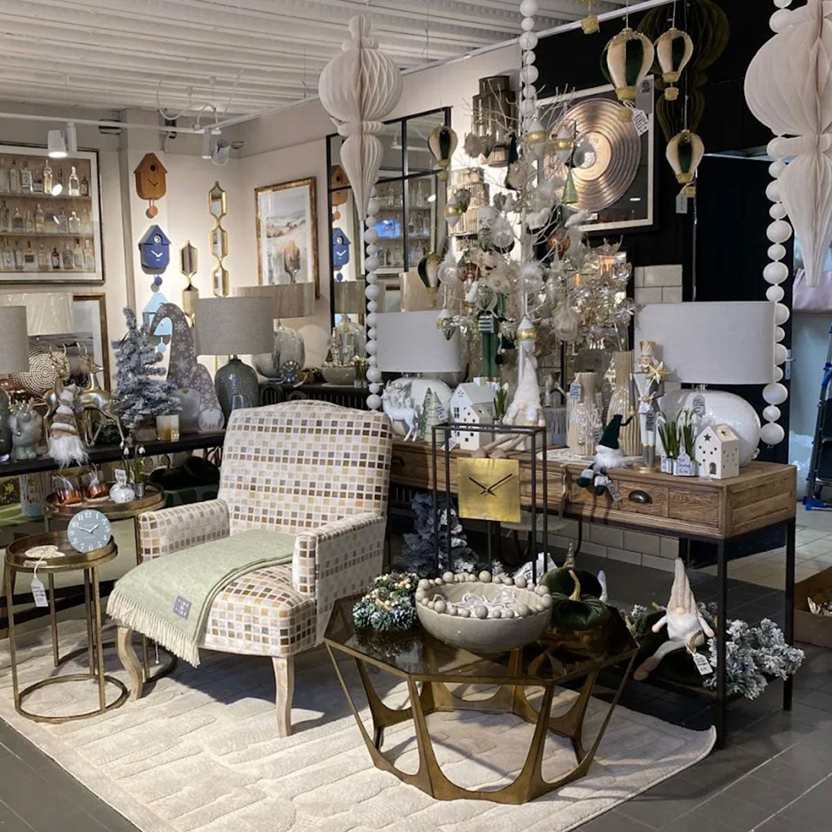 Decorative interior setting with a chair, table, and various decorative items in a store.