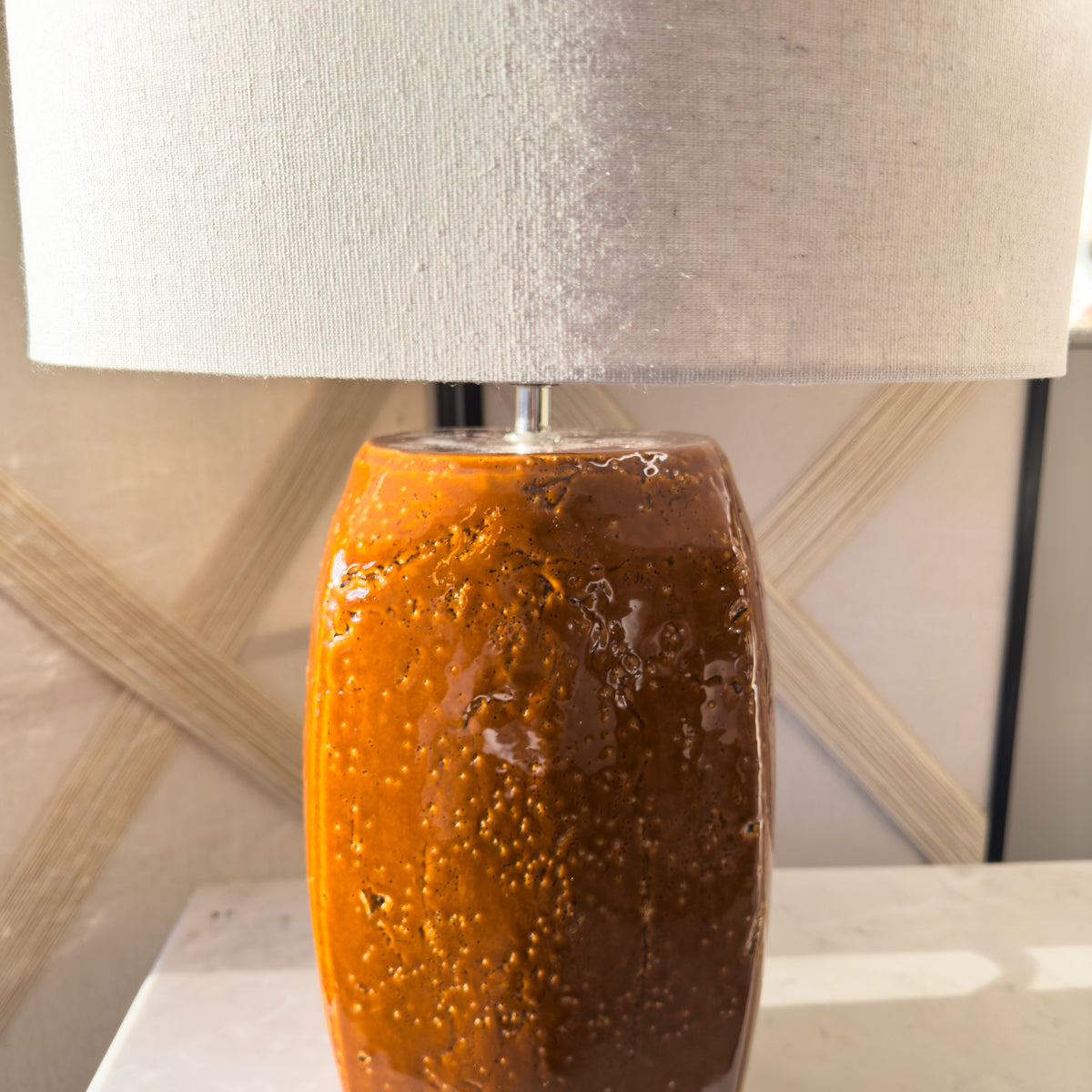 A mustard table lamp with a textured ceramic base and neutral linen shade.