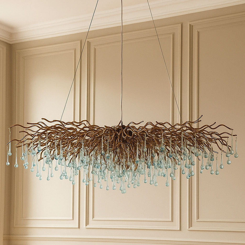 Decorative chandelier with hanging glass droplets against a beige paneled wall.
