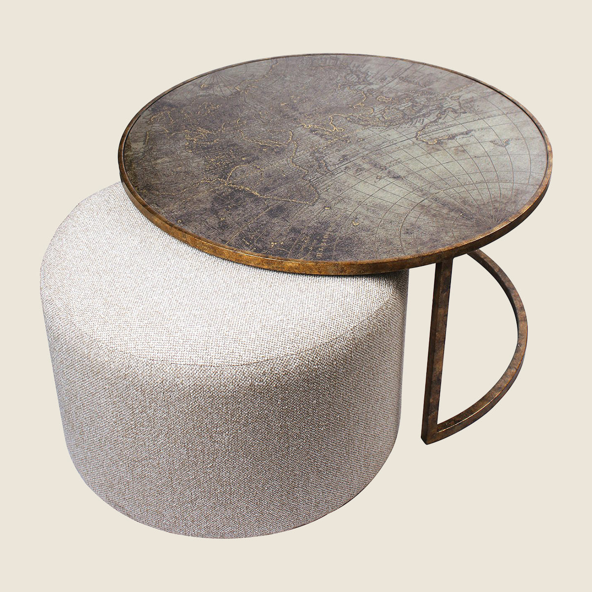 A round coffee table with a distressed dark brown map-patterned top and a curved metal frame, paired with a cylindrical upholstered ottoman in a light beige textured fabric, set against a solid light beige background.