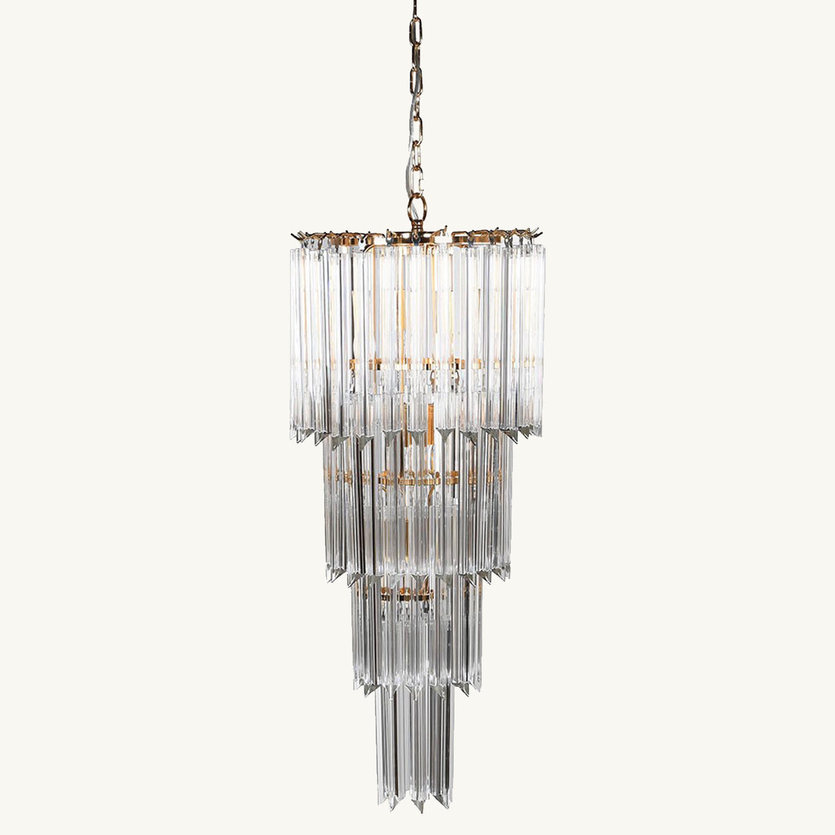 A tiered glass chandelier with gold accents, featuring rectangular crystals arranged in layers.