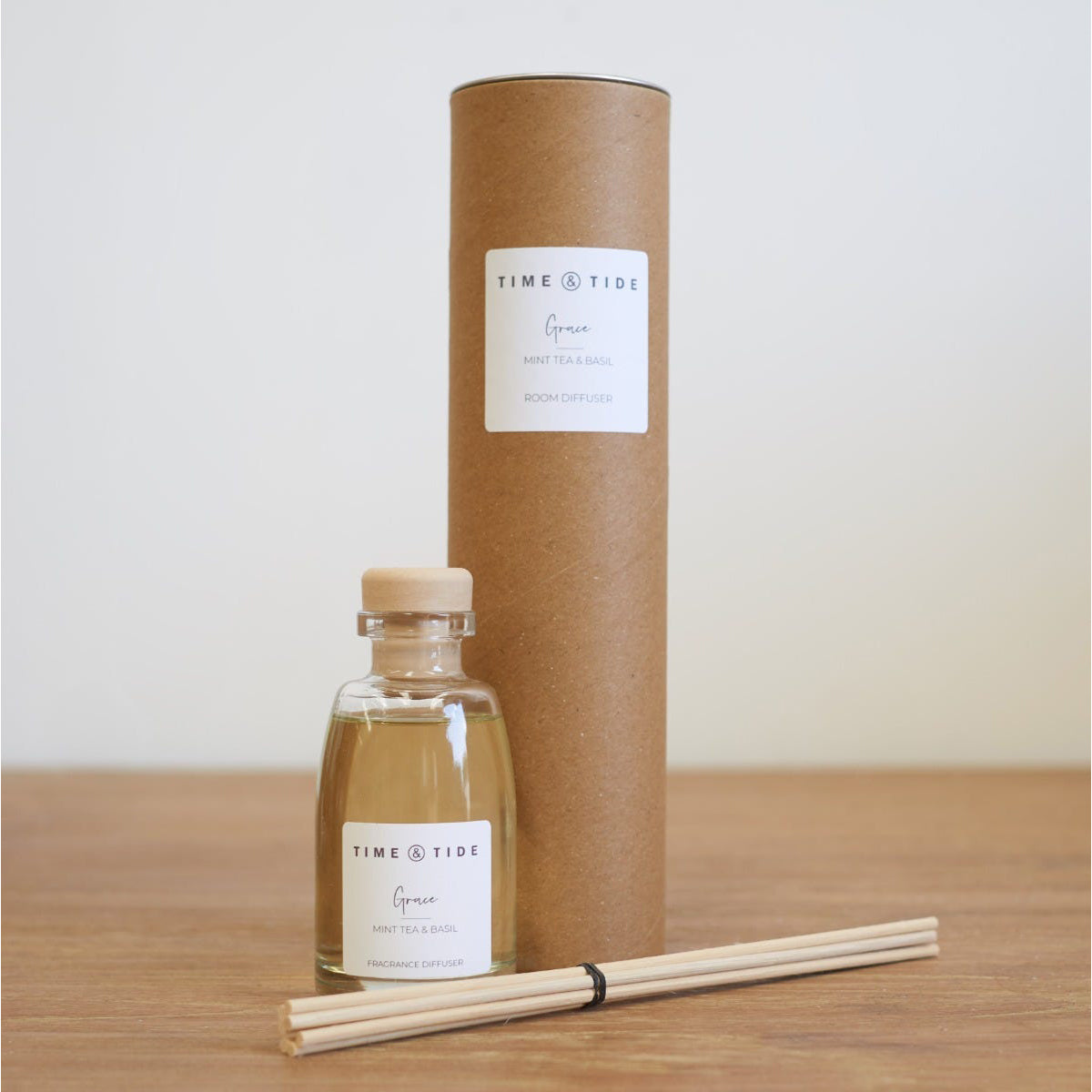Time & Tide diffuser bottle with cardboard tube and reeds on a wooden surface