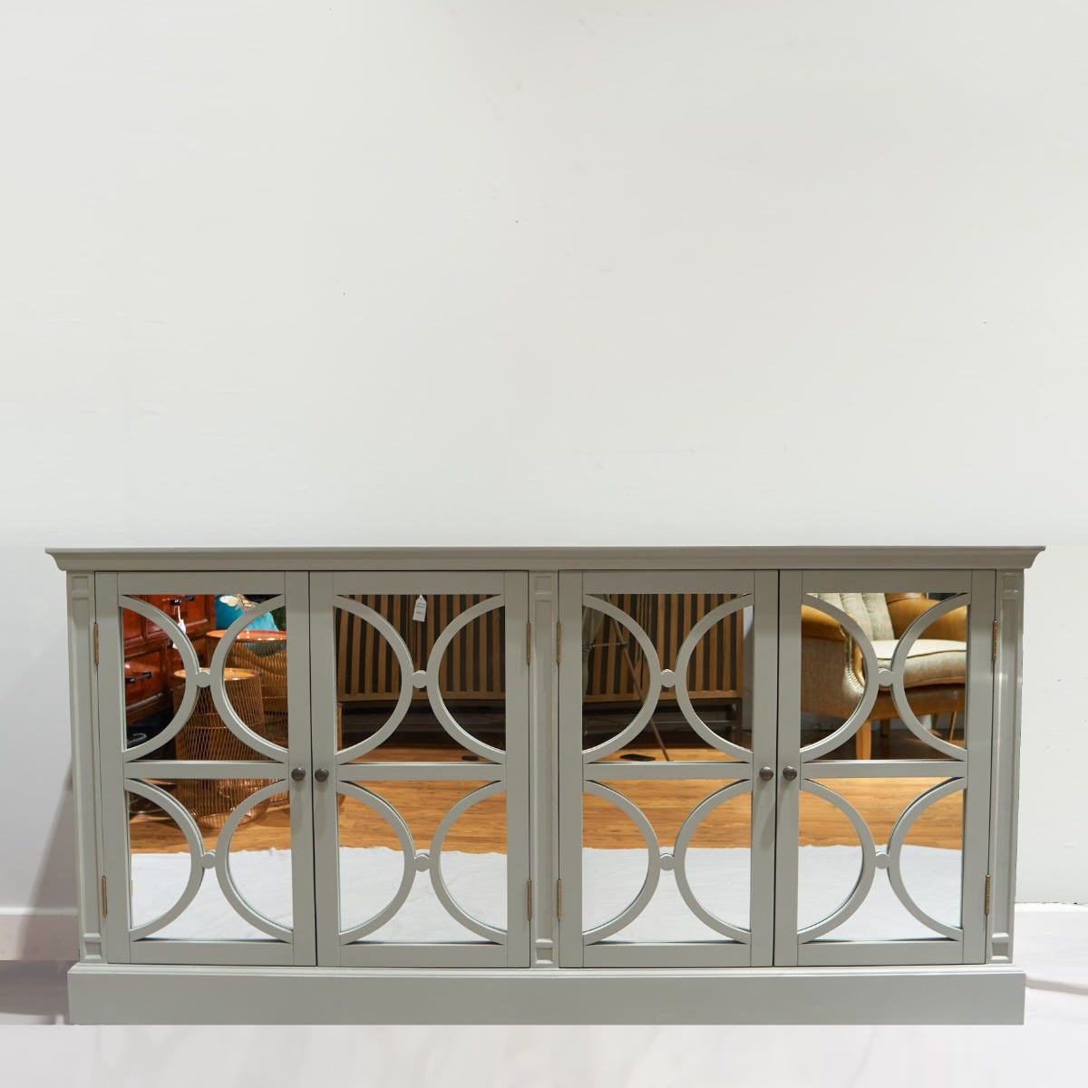 Grey traditional sideboard with decorative circular mirrors on a white background