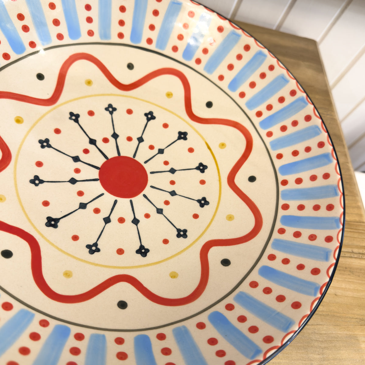 Decorative plate with colorful patterns on a wooden surface