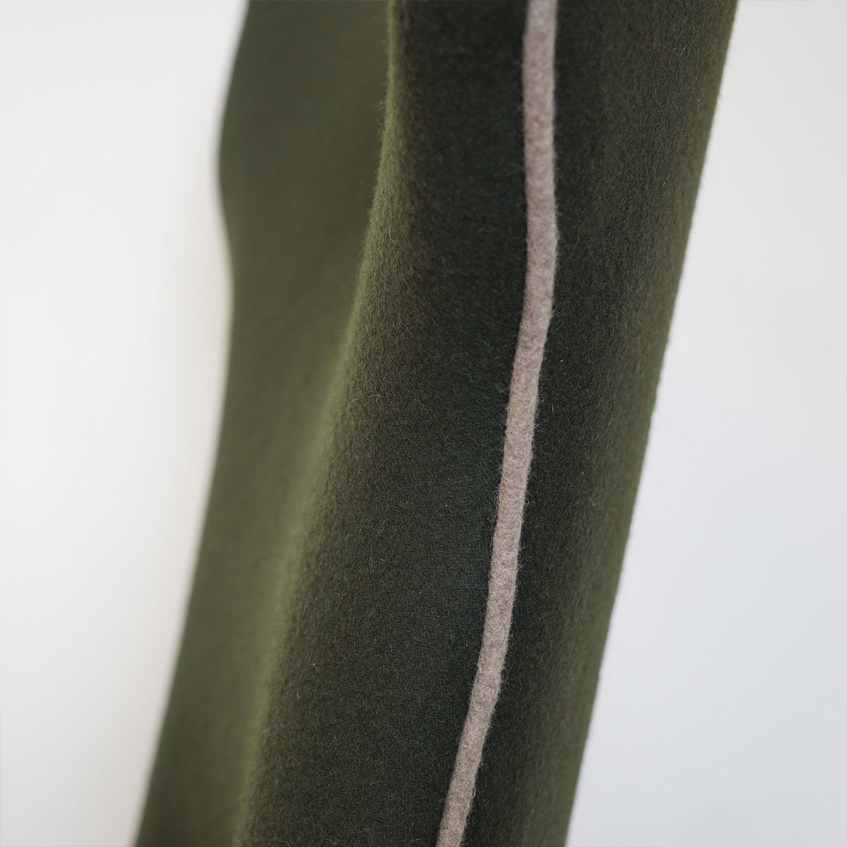 Dark green felt dining chair with a white stripe on a white background
