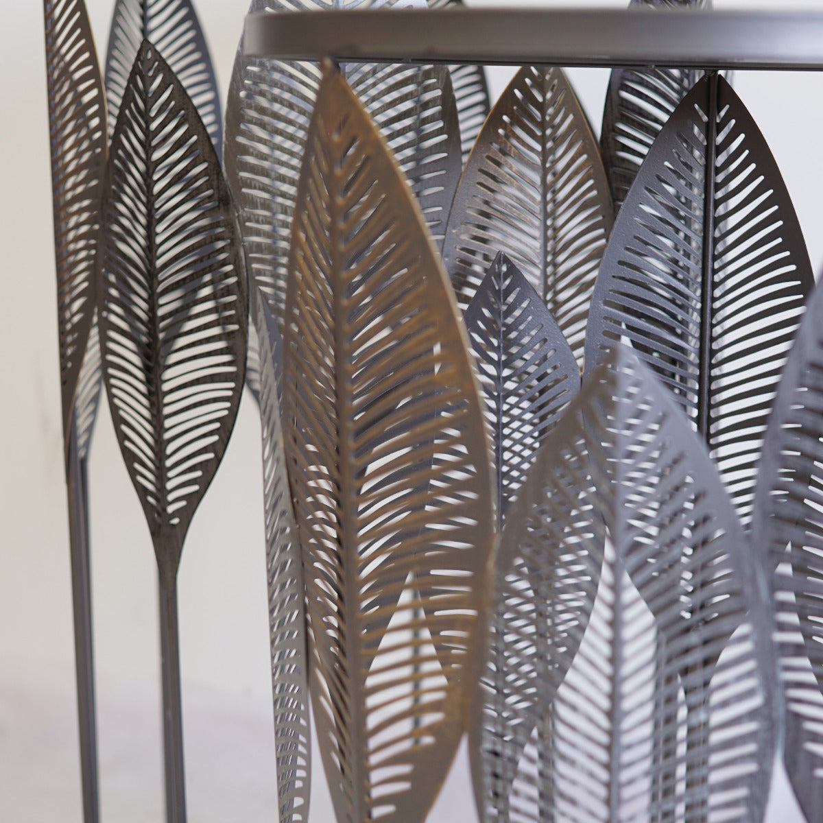 A side table with metal leaves with a metallic sheen on a neutral background