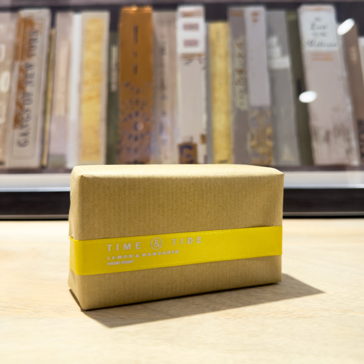 Kraft paper wrapped soap with a yellow label on a wooden surface