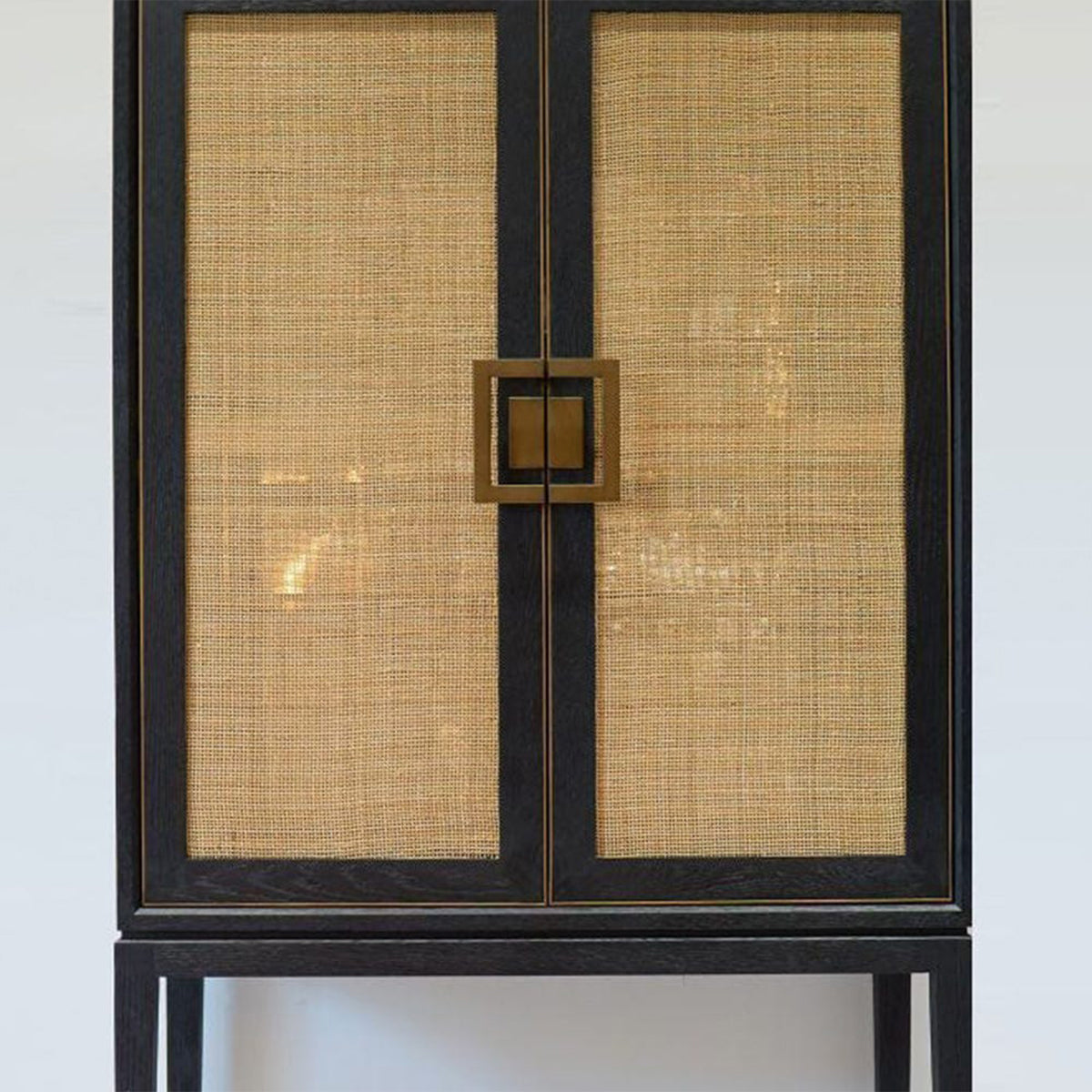 Cabinet with woven doors and black frame on a white background