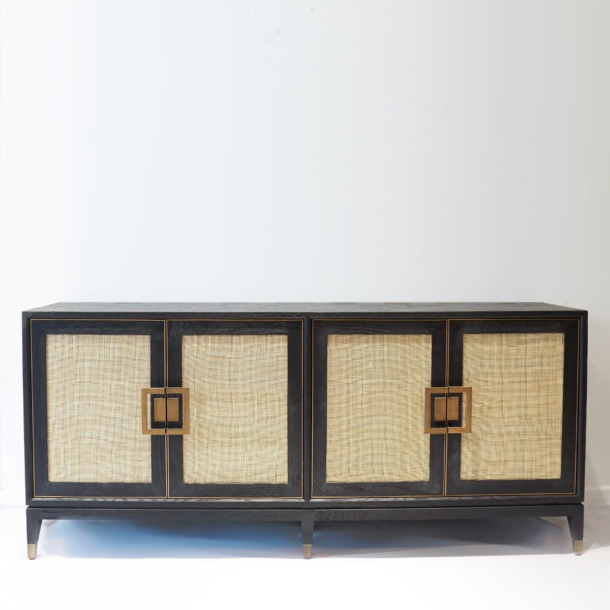 Cabinet with wicker doors and gold accents on a white background