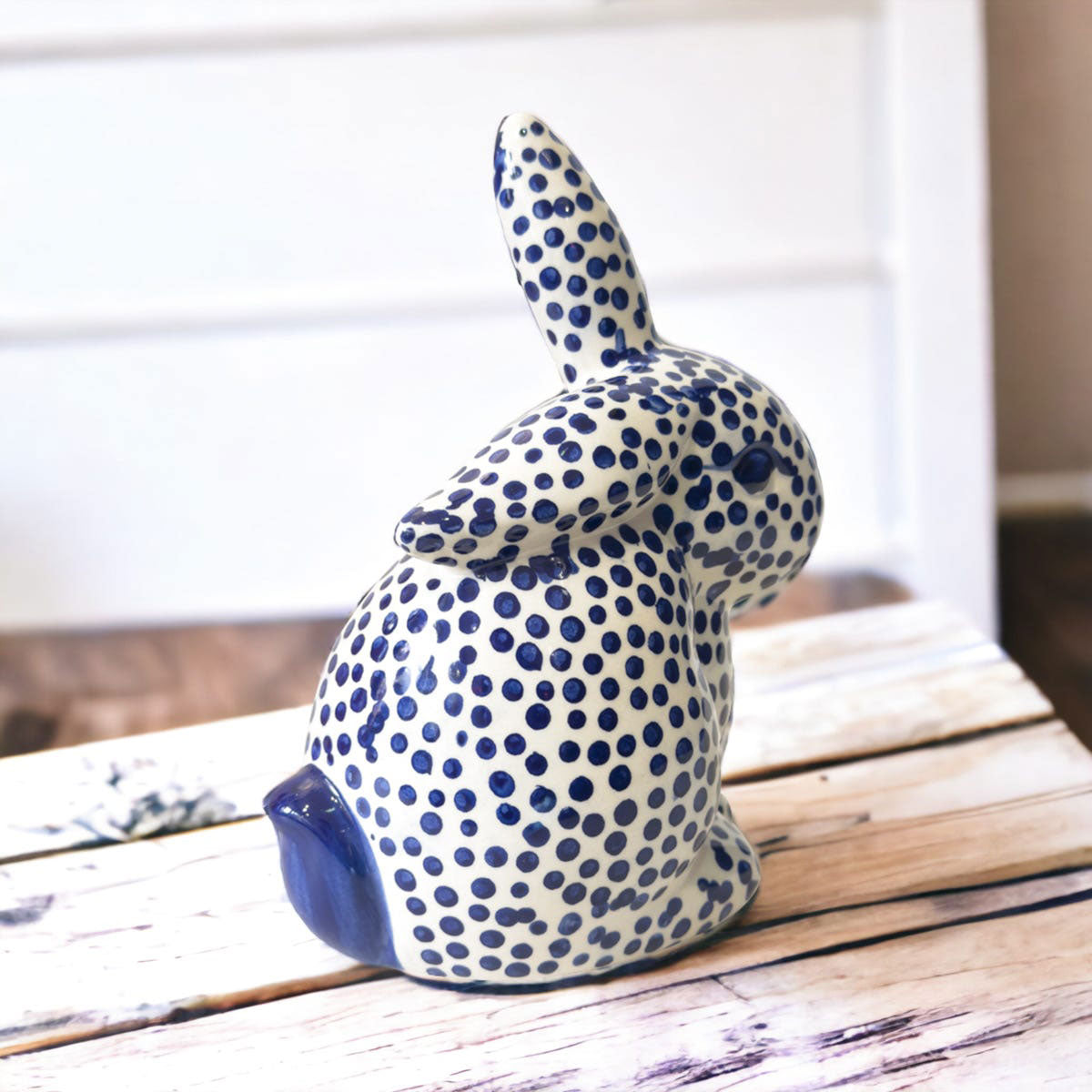 Ceramic bunny figurine with blue dot pattern on a wooden surface