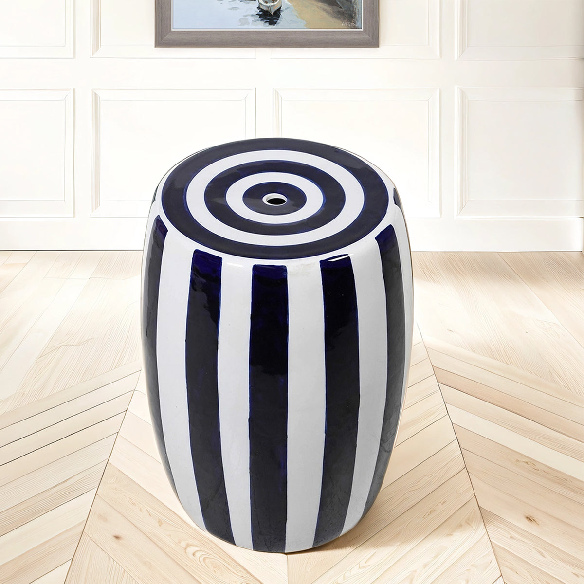 Decorative stool with blue and white striped pattern on a wooden floor.