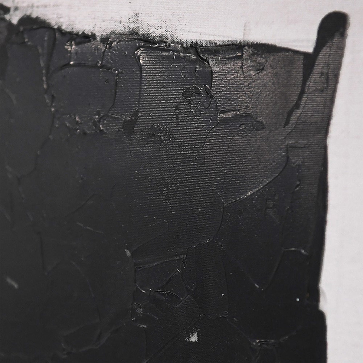 A close up of black paintwork on a rectangular wall canvas.