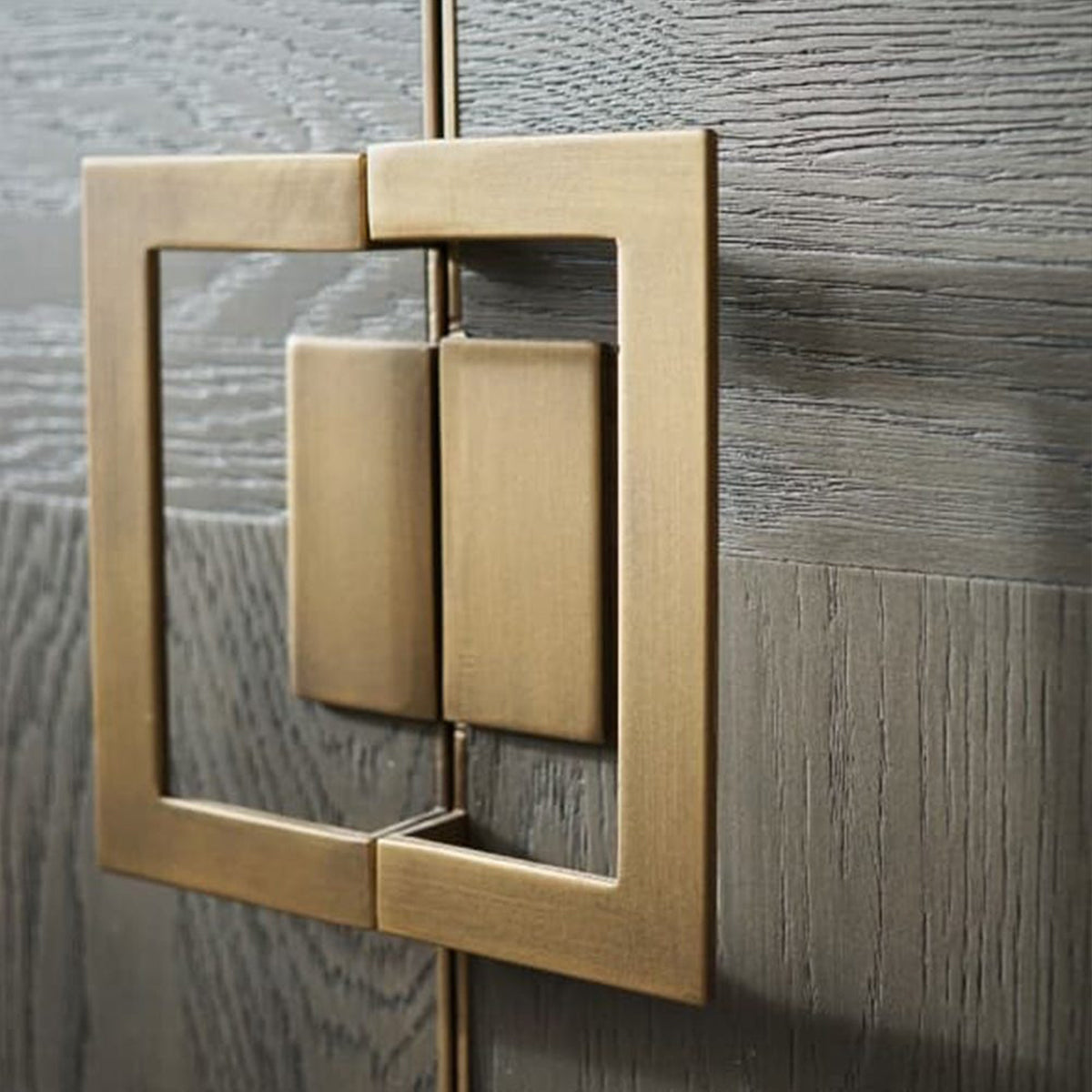 Brass door handle on a parquet wooden cabinet door