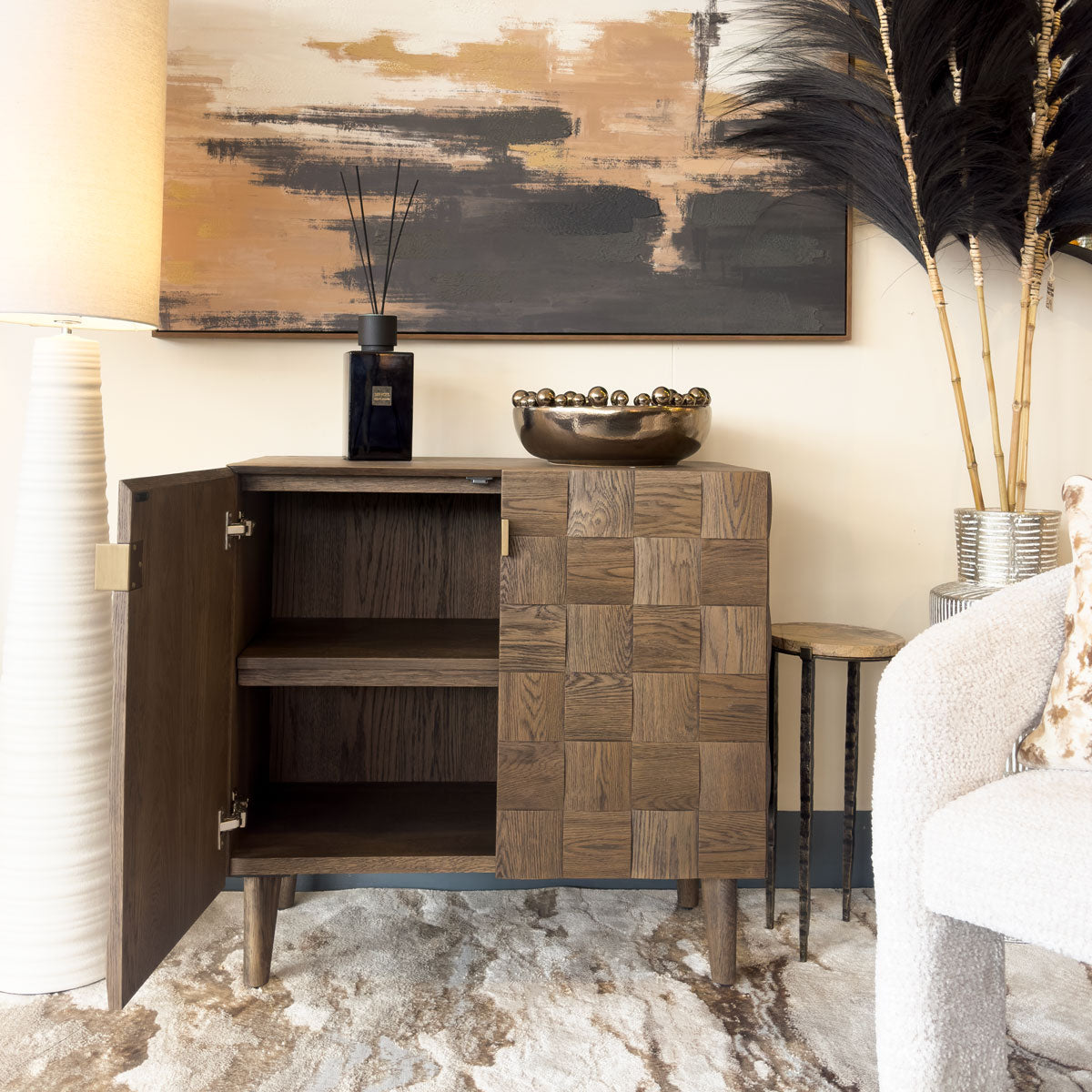 Wooden sideboard with abstract painting and decorative elements in a room setting