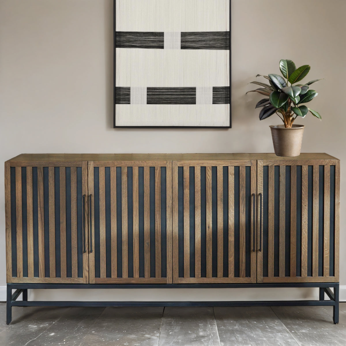 Wooden sideboard with vertical slats and black handles in a room with a plant and abstract art.
