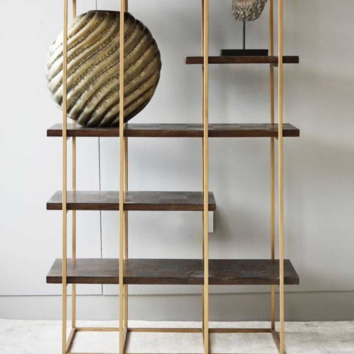 Wooden shelf with gold frame against a white wall
