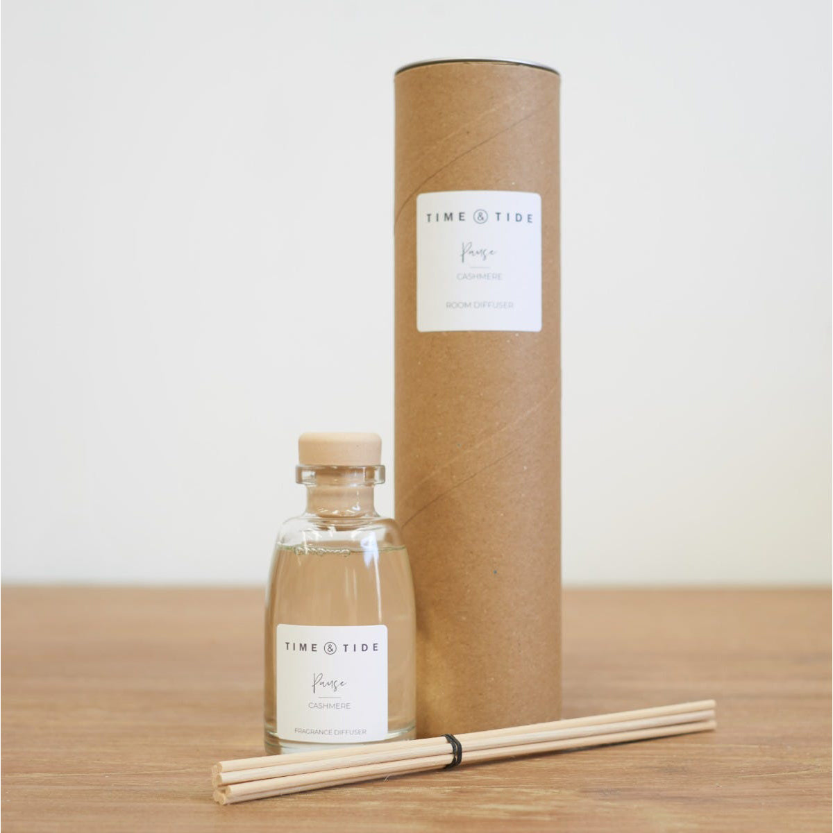 Time & Tide diffuser bottle with packaging and sticks on a wooden surface