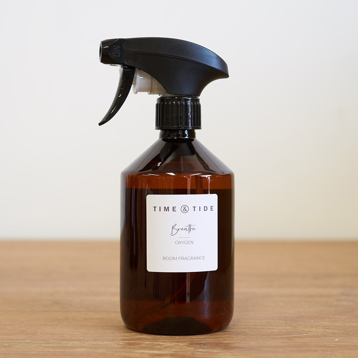 Fresh room spray bottle with black nozzle on a wooden surface