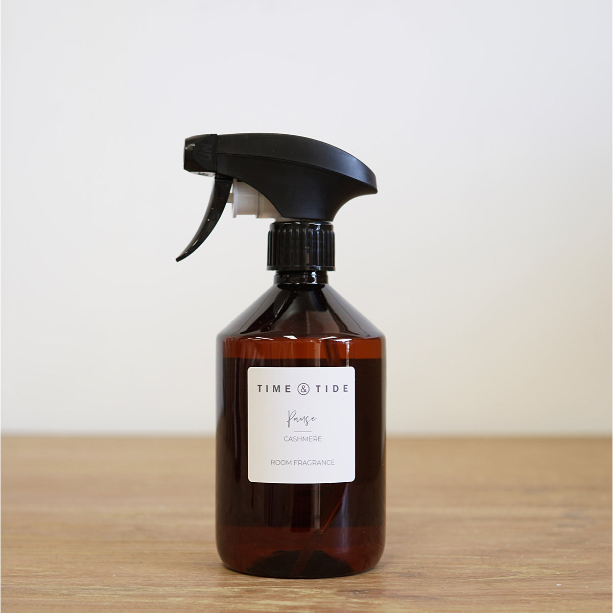 Brown spray bottle with black nozzle on a wooden surface