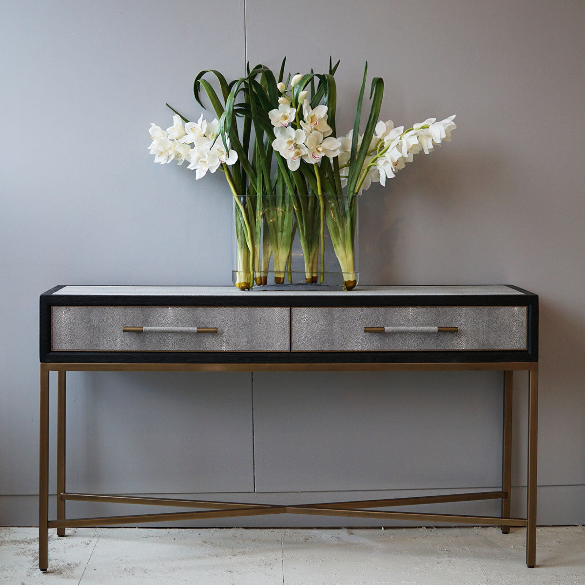 Shagreen hallway table with a vase of white flowers against a gray wall