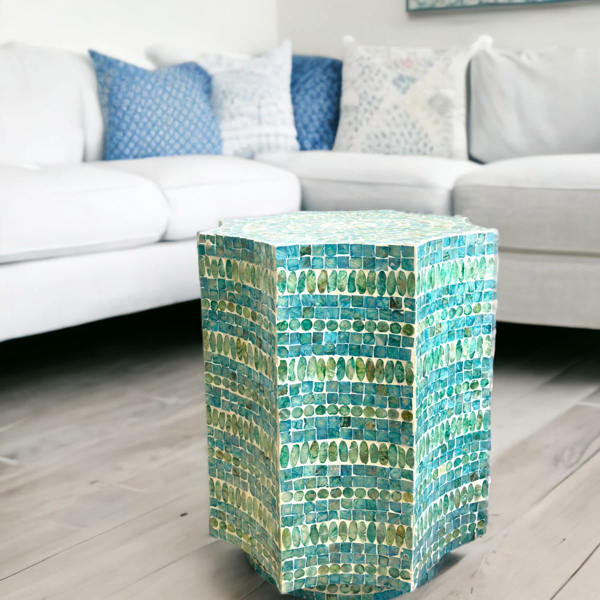 Mosaic patterned side table in a living room setting with a sofa and cushions.