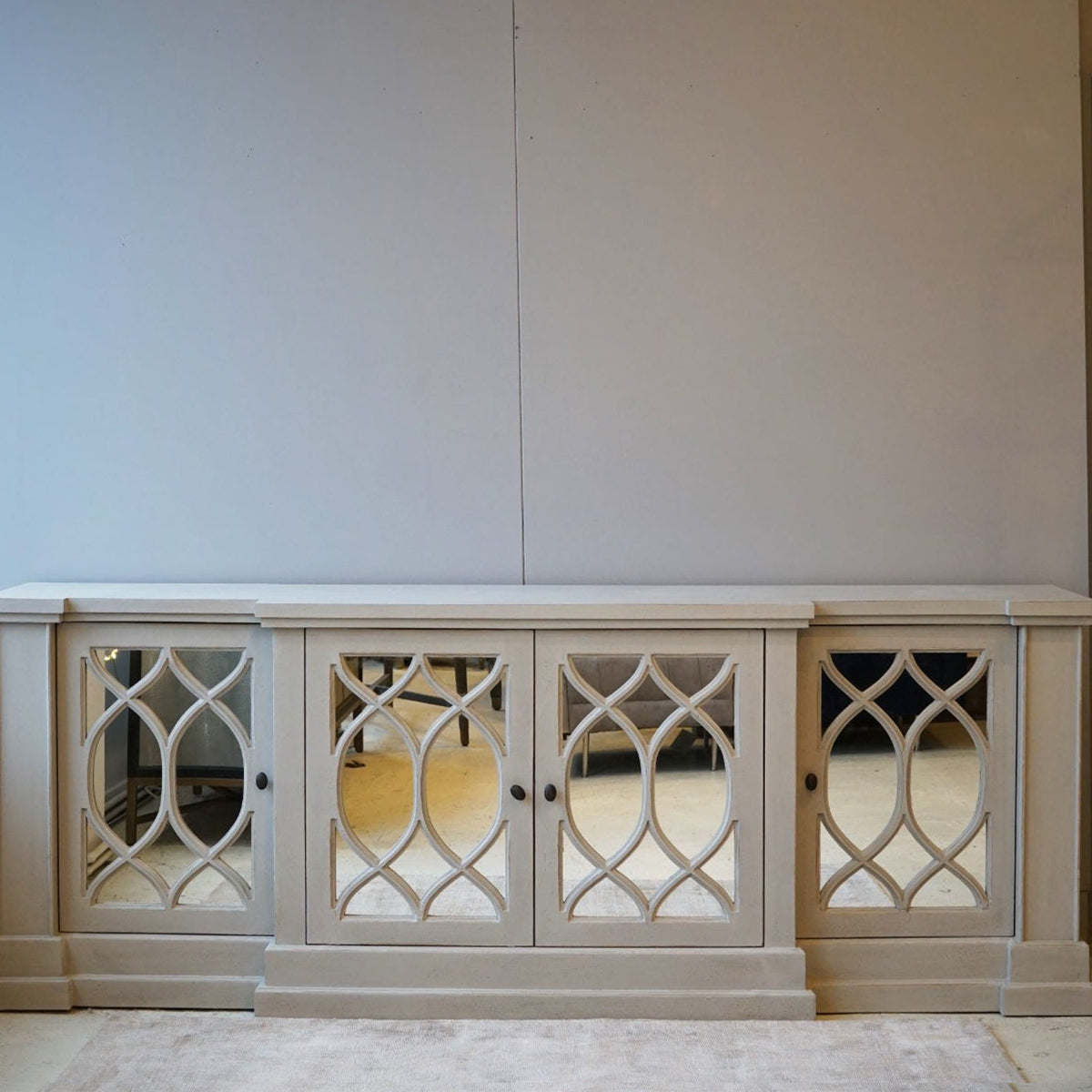White cabinet with decorative glass panels against a white wall