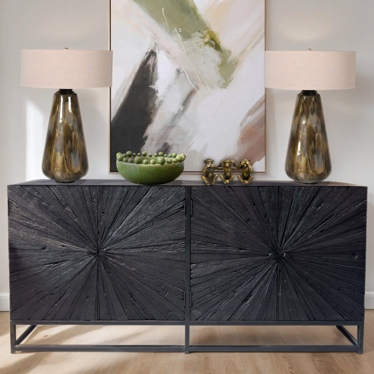Black starburst cabinet with decorative items and abstract art in the background