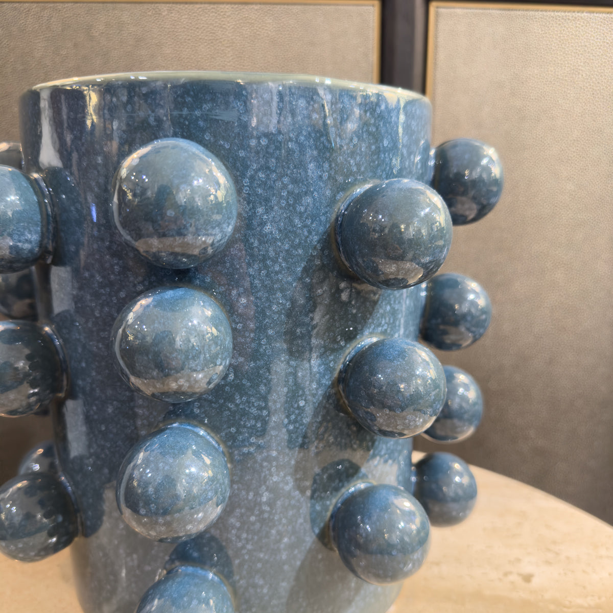 A close up of a bobbled blue plant pot.