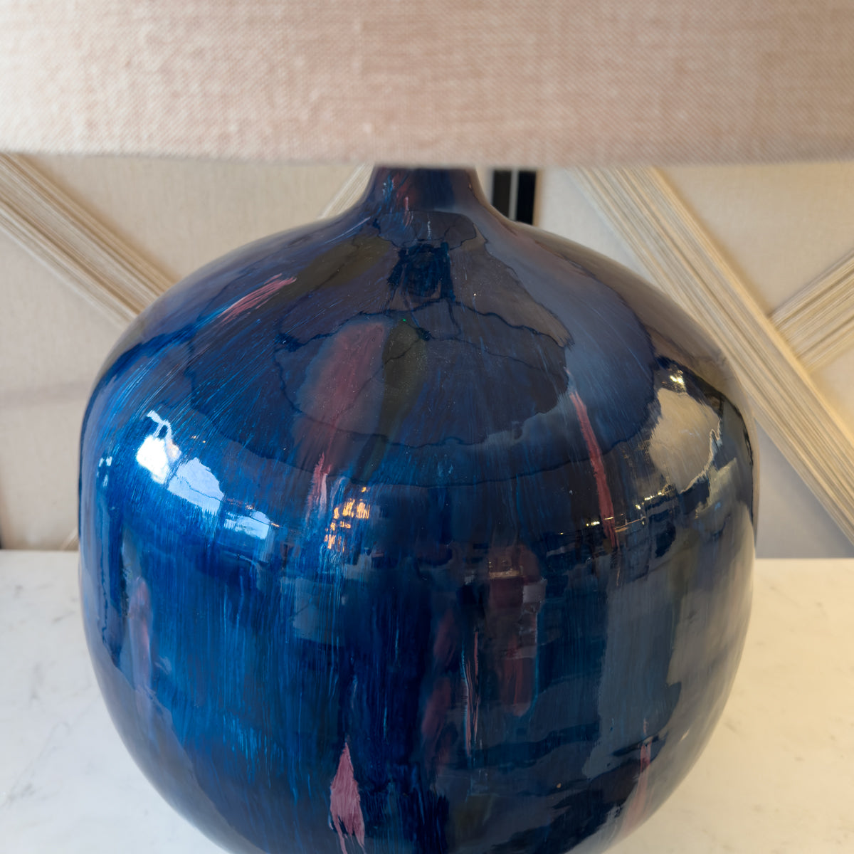 A close up of a blue table lamp with a glossy enamel finish.