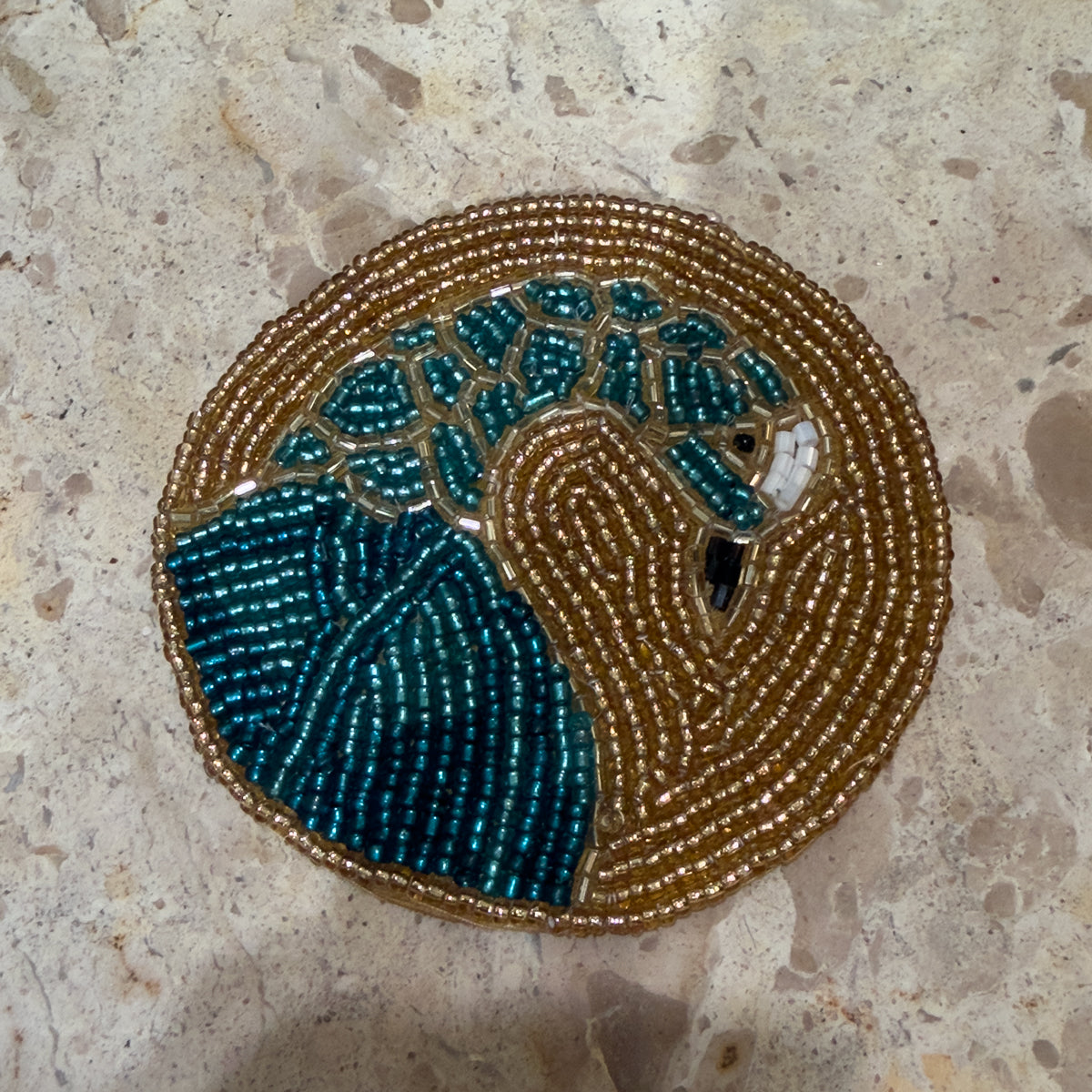 ornate circular beaded gold coasters with gold peacock.