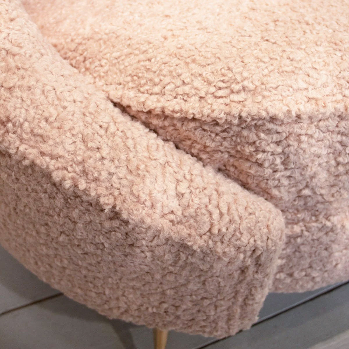 A close up of a pink boucle occasional chair.