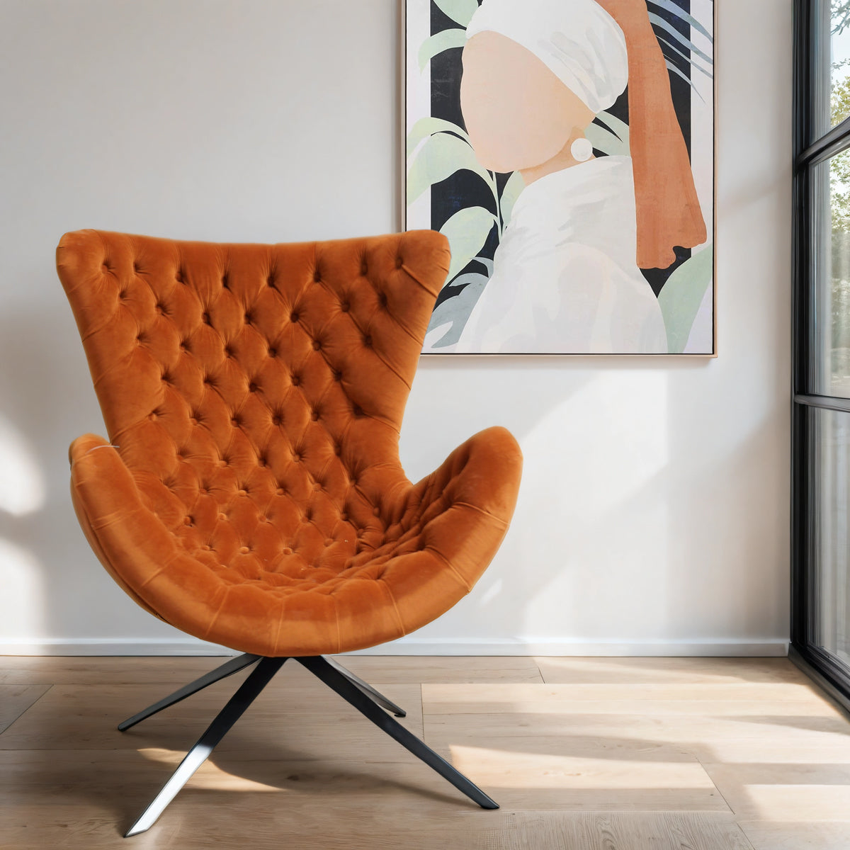 A deep orange living room chair infront of a canvas featuring a female silhouette in orange & black.