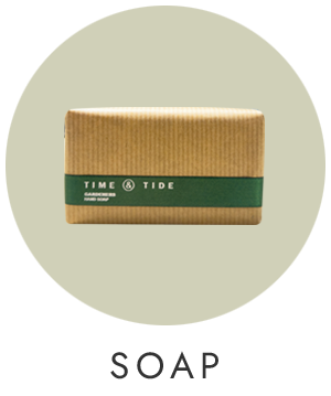 A pale green circle with a picture of a bar of soap tied with a green ribbon in the centre.